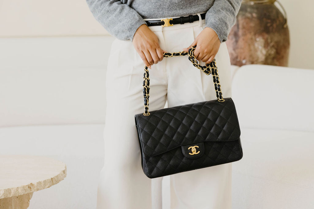 A preloved luxury handbag by Chanel in black leather with gold gilding